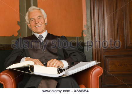 Portrait of a lawyer sitting in an armchair with a file in his lap