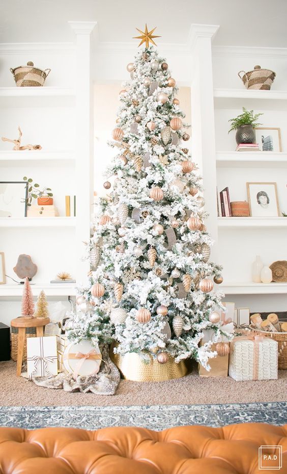 a beautiful flocked Christmas tree with ribbons, grey and copper metallic ornaments with a star topper
