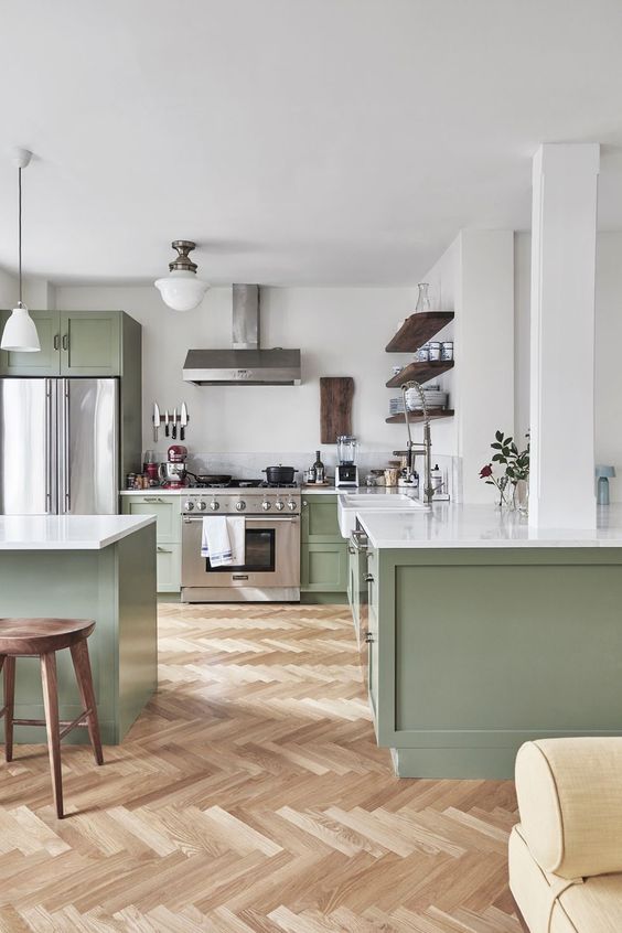 a chic contemporary kitchen in light green and white, with dark wooden touches and white countertops is very welcoming