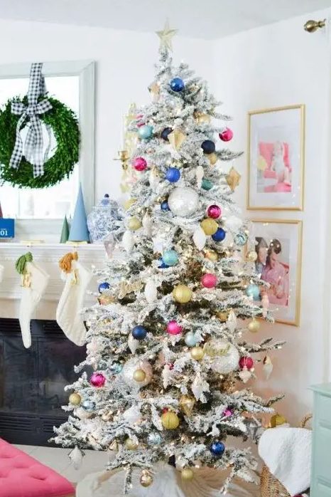 a flocked Christmas tree with colorful ornaments and lights plus a star topper for a fun touch