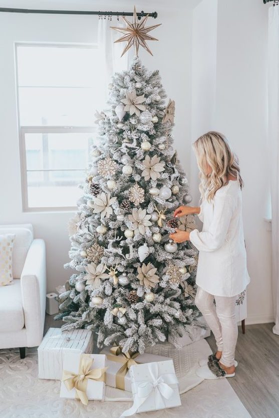 a flocked Christmas tree with oversized fabric flowers, pinecones and ornaments is a cool and super glam idea to rock