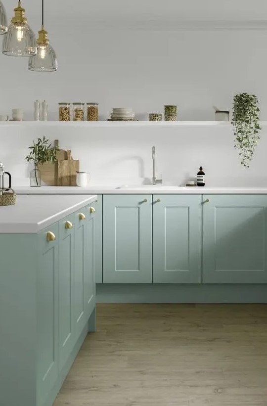 a mint green lower cabinet kitchen with white tone countertops and a large open shelf, brass and gold handles