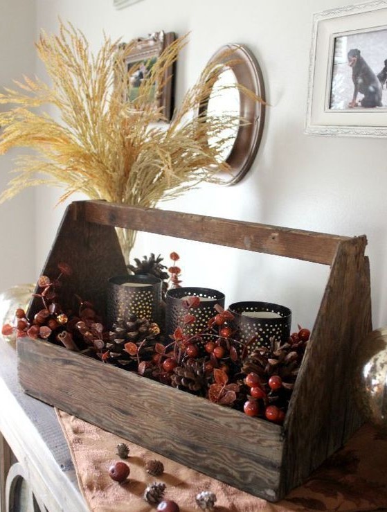 a natural autumnal toolbox centerpiece with berries, cinnamon bark, candle holders and a wheat arrangement
