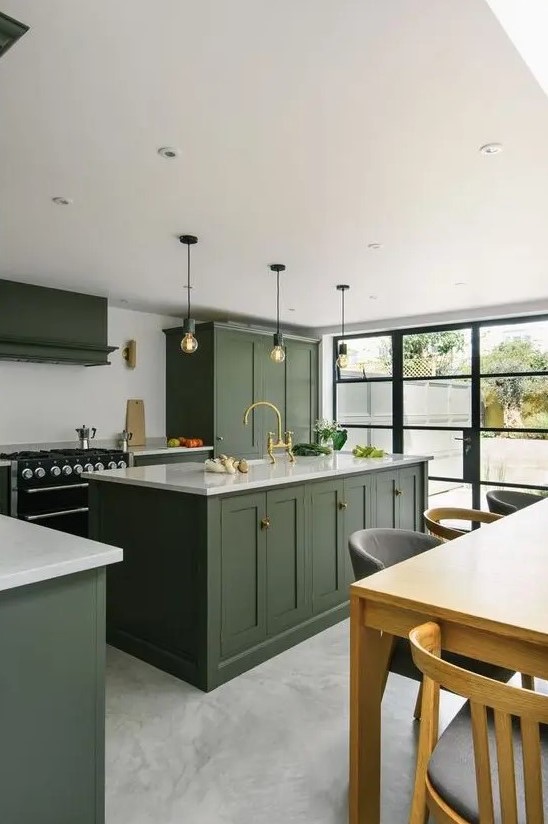 a stylish hunter green kitchen with vintage cabinetry, a white backsplash and countertops, pendant bulbs and a glazed wall