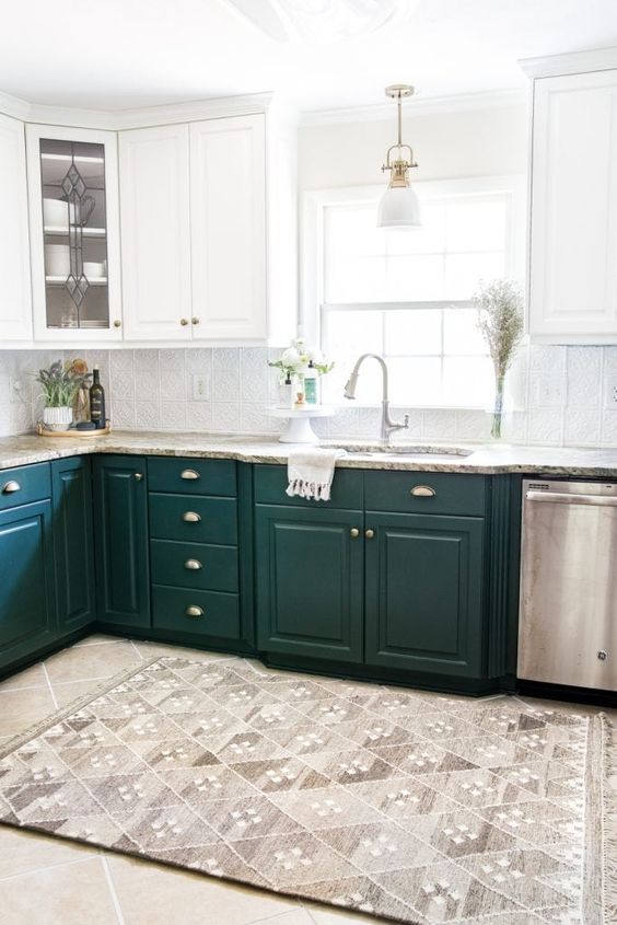 a stylish kitchen with dark green and white cabinets, stone countertops and touches of metallics here and there