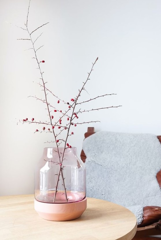 A stylish pink and copper vase with branches with berries is a cool Nordic fall decoration
