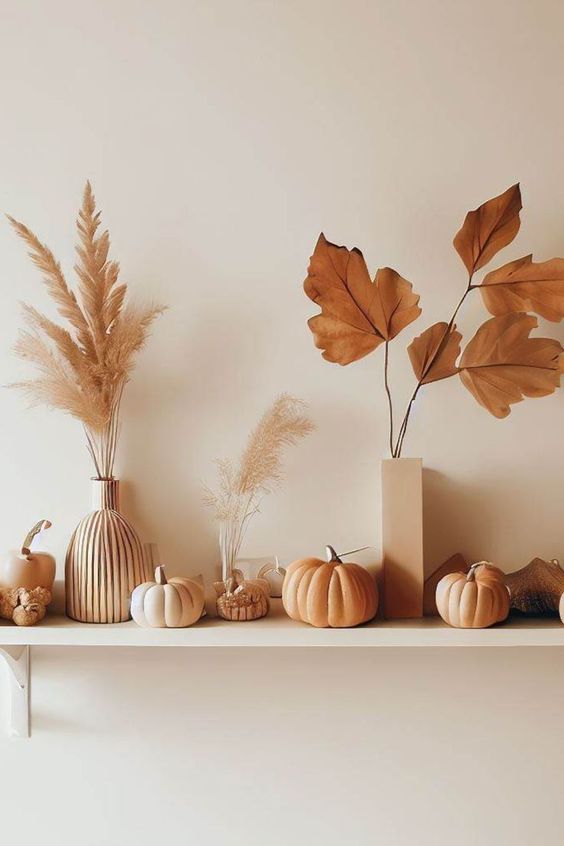 An open shelf with dried lavender flowers and grasses as well as some artificial pumpkins is ideal for Scandinavian fall decor