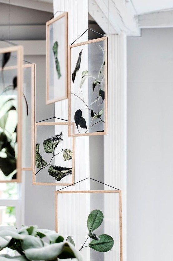 Framed greenery and foliage in wooden frames hang here and there, adding a natural touch to the space