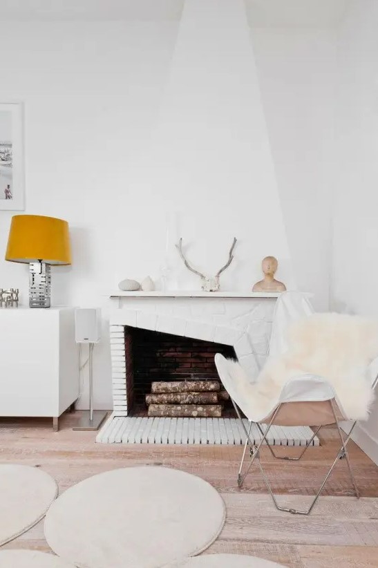 White faux fur covers and rugs, antlers, pebbles and firewood give this room a Nordic yet autumnal touch