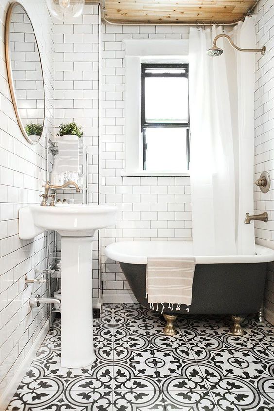 This small black and white room is embellished with mosaic tiles on the floor and a wooden ceiling