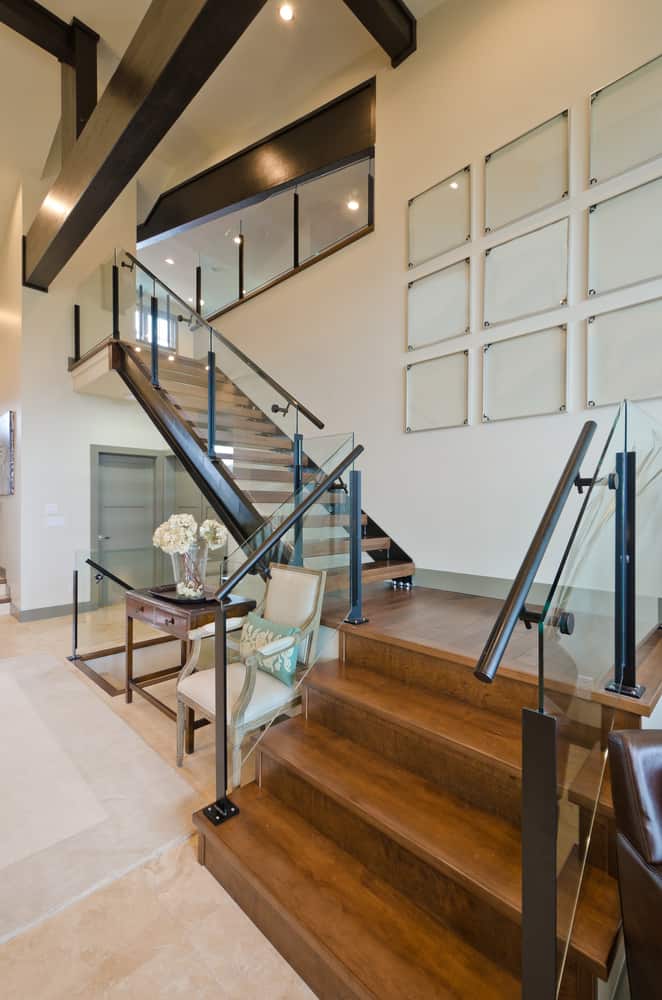 Modern wooden staircase with glass wall art