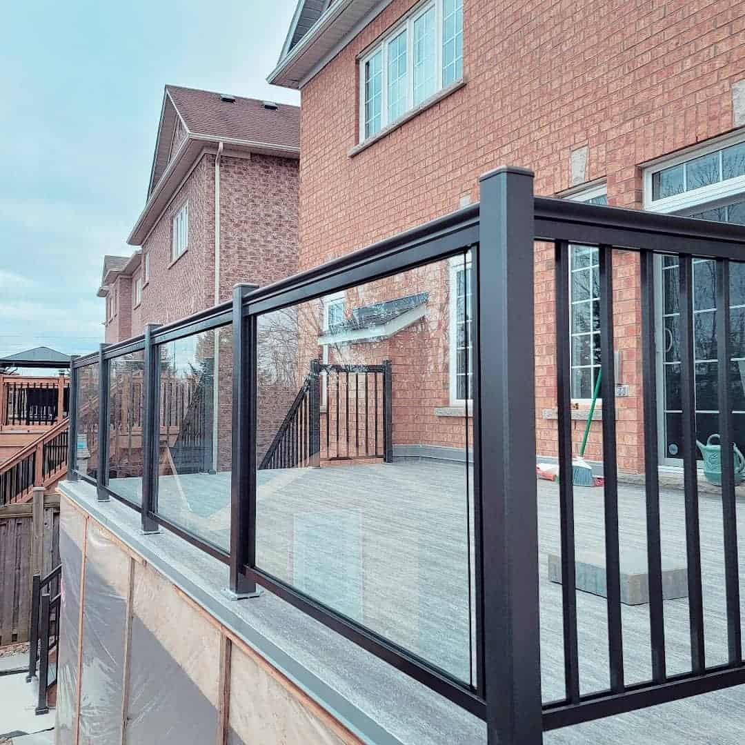 modern two-tone deck, gray pavers, black glass railing