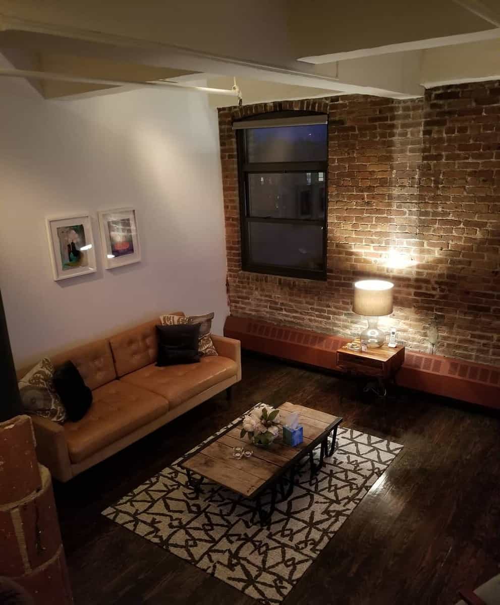 exposed brick wall, living room, hardwood floors, light brown couch
