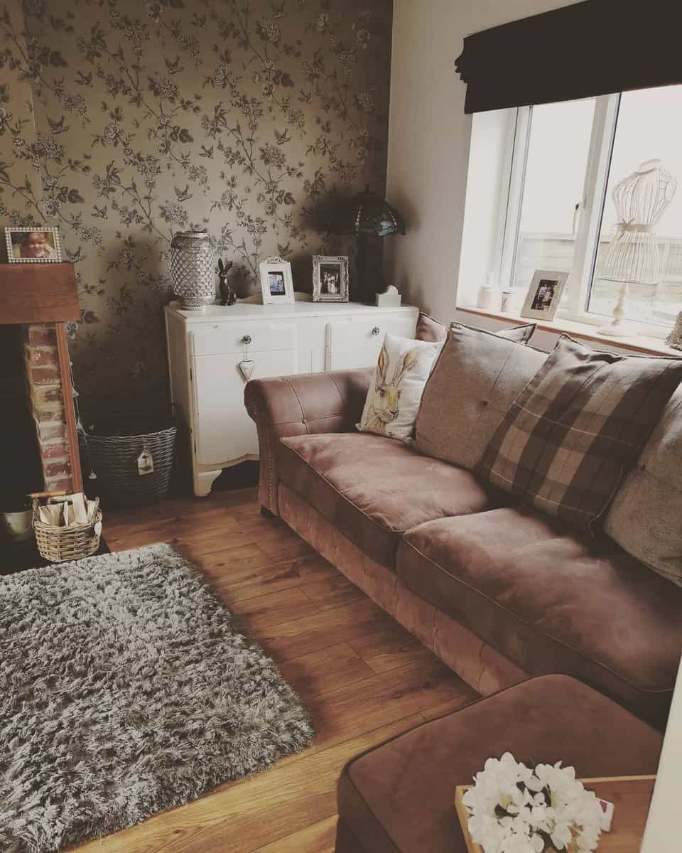 small living room with floral wallpaper, couch, white chest of drawers