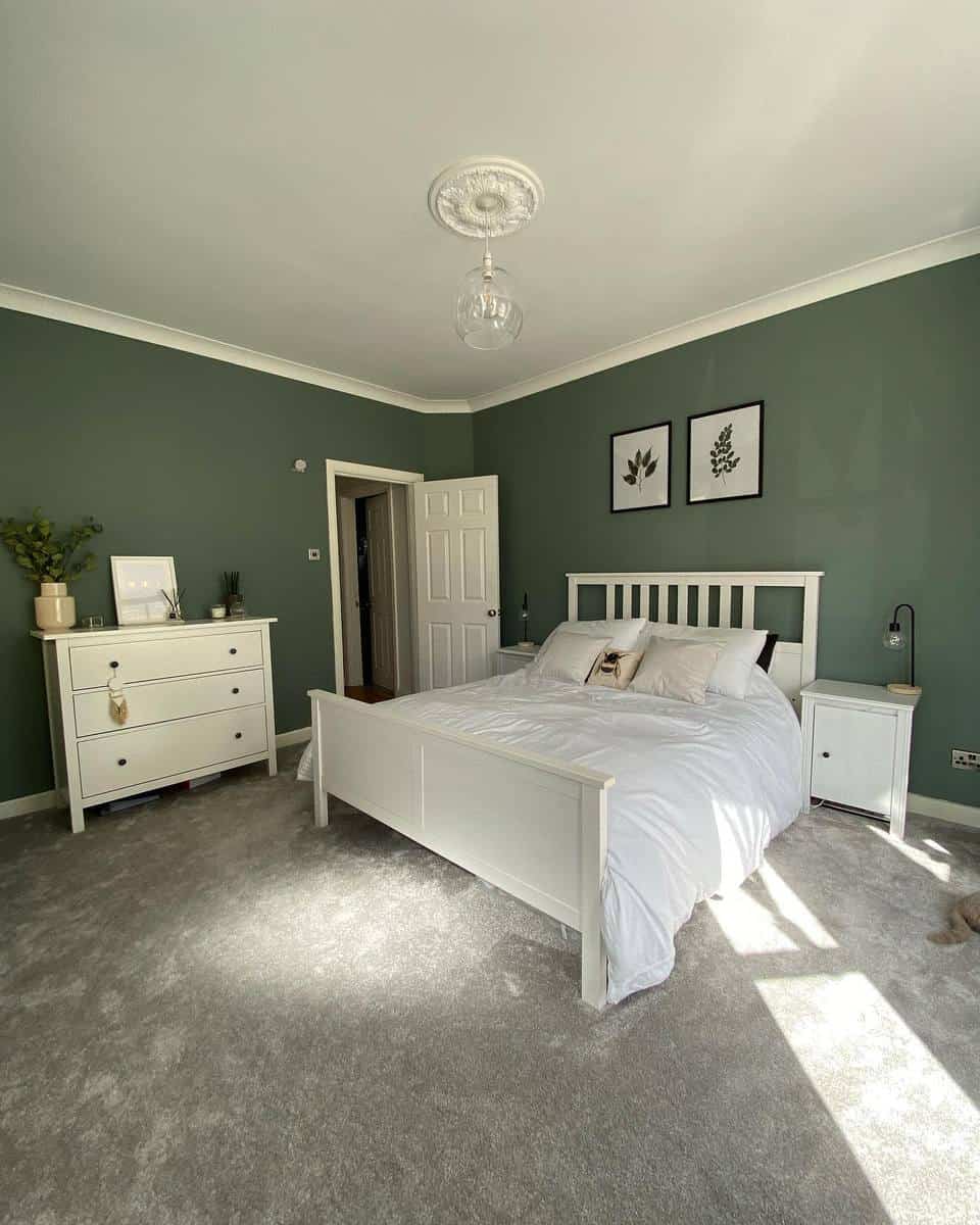 Classic green wall, bedroom, white wooden bed frames, cabinets, framed wall art, gray carpet 