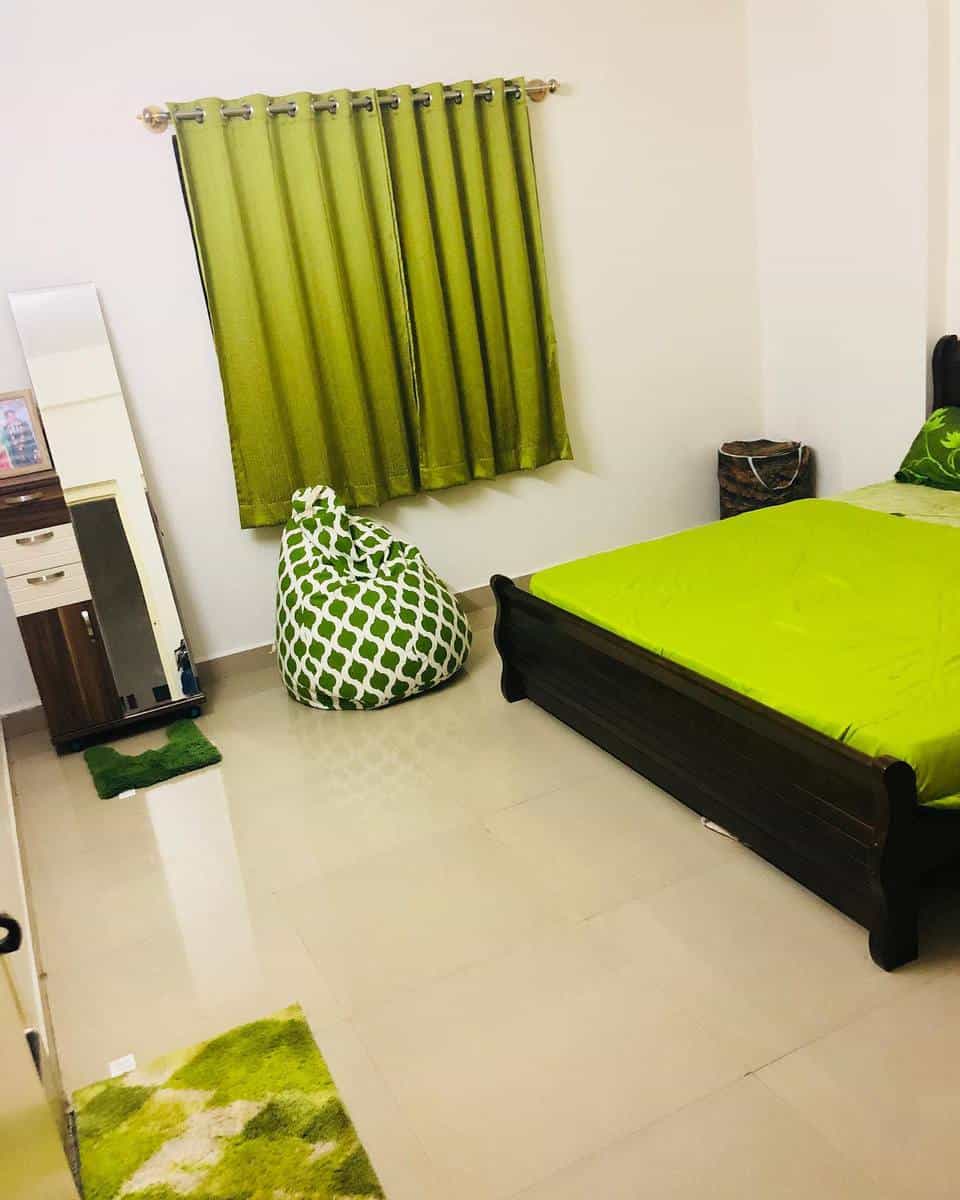 Simple lime green curtains and bedspread, beanbag, tiled floor