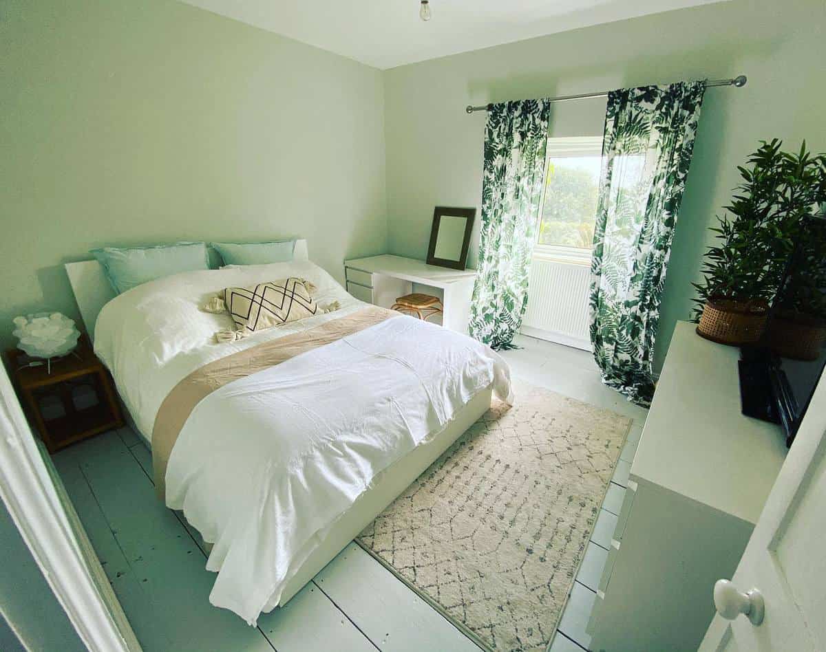 Green fern design curtains in master bedroom, white bedboards 