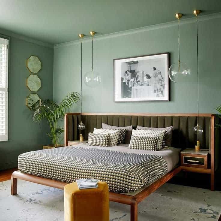 Green bedroom, vintage wooden bed, framed photo, hexagonal wall mirrors, pendant lighting 