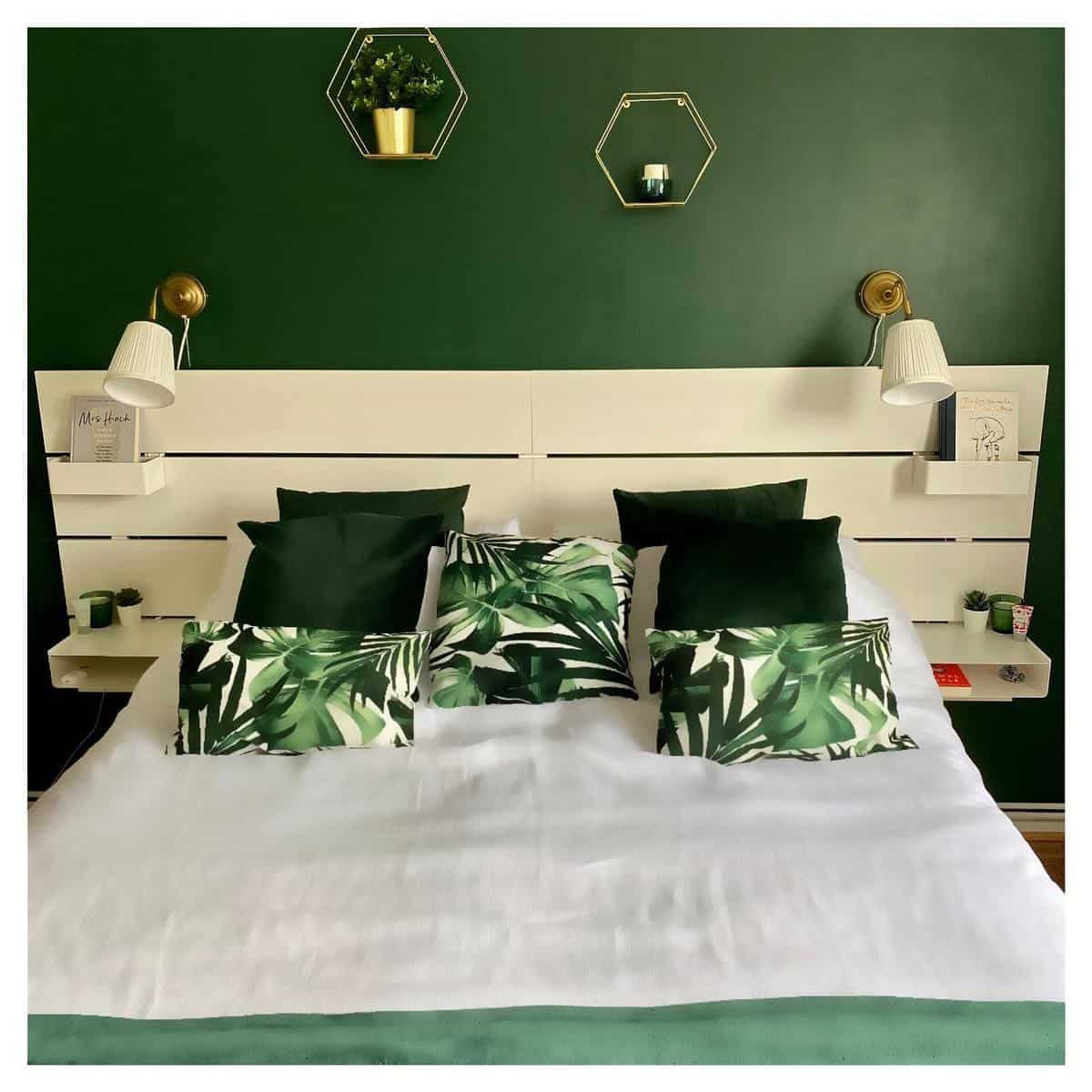 Modern bedroom with green wall, wooden panel, bed frame, wall sconces and lights