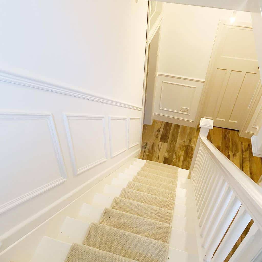 white wall paneling, carpeted stairs 