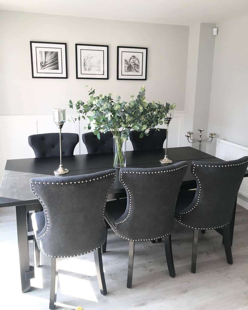 Black dining table and chairs with framed wall art