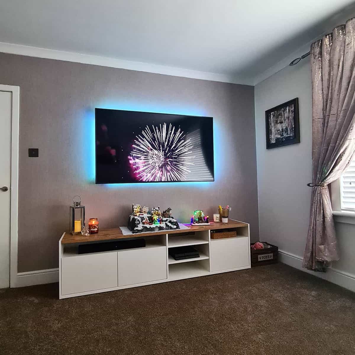 Small living room with brown carpet and wall-mounted television