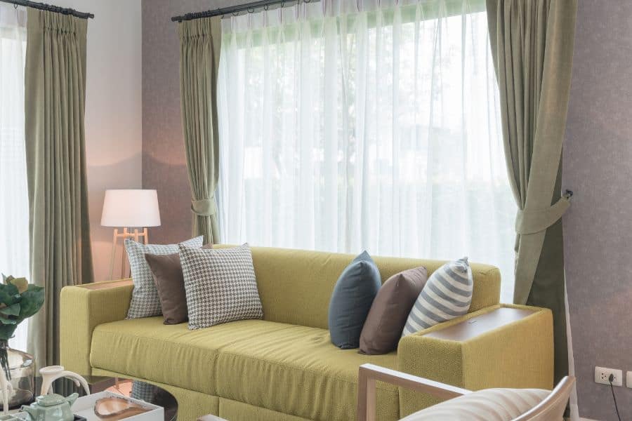 Soft green curtains, yellow sofa in the living room