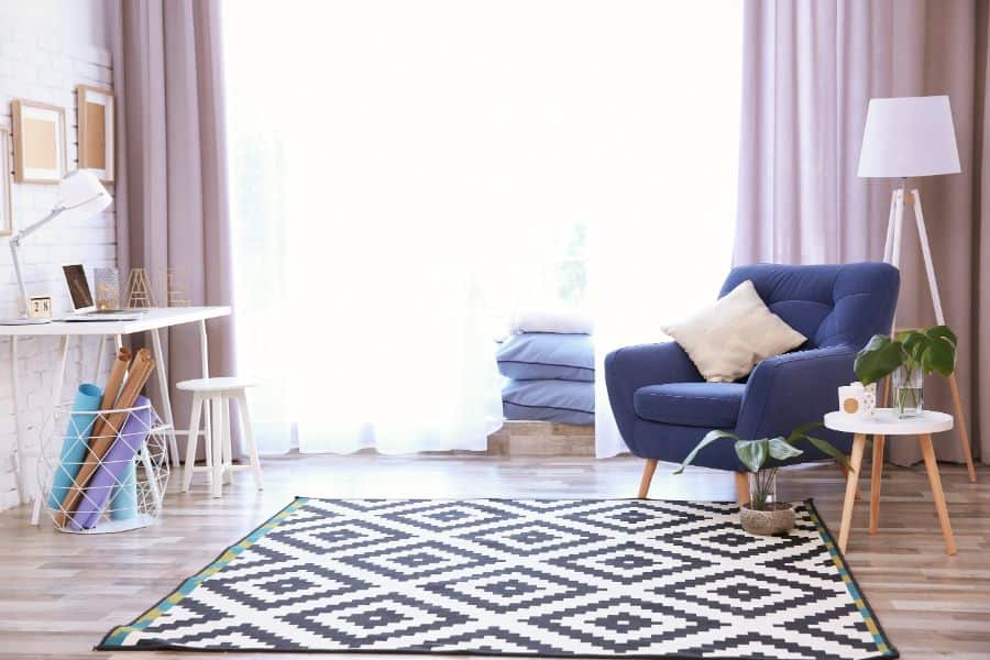 Purple curtains, blue accent chair with patterned rug 