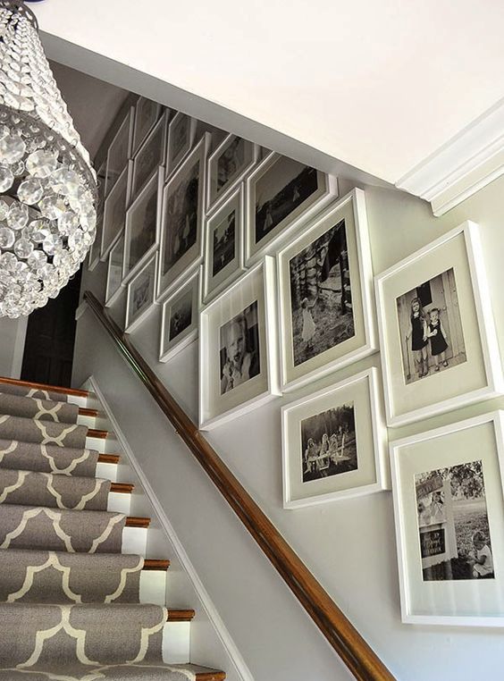 An oversized black and white gallery wall with matching white frames is a great idea to give the room a vintage feel, and white frames make it look light