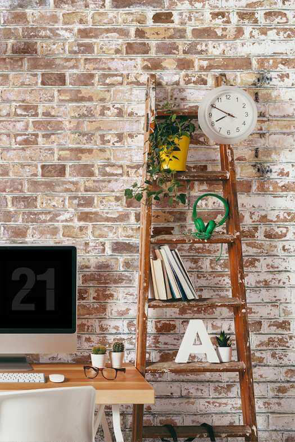 Stylish home office with brick wall and storage space on the ladder