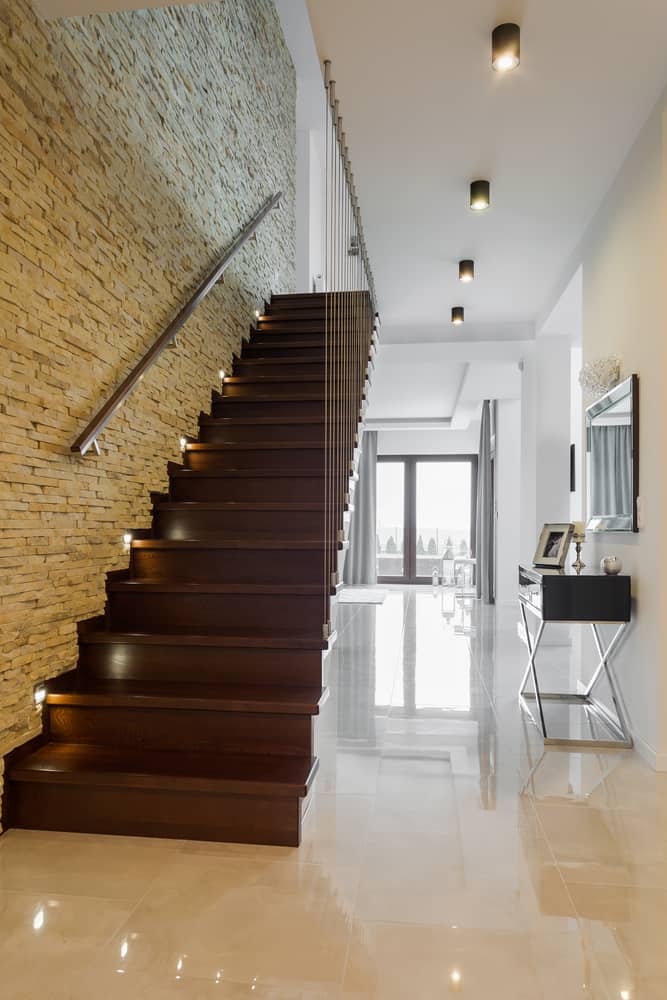 Staircase with brick accent wall 