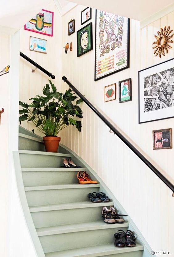 A bright and versatile gallery wall with lots of fun artwork in different frames is a cool idea for stair decor