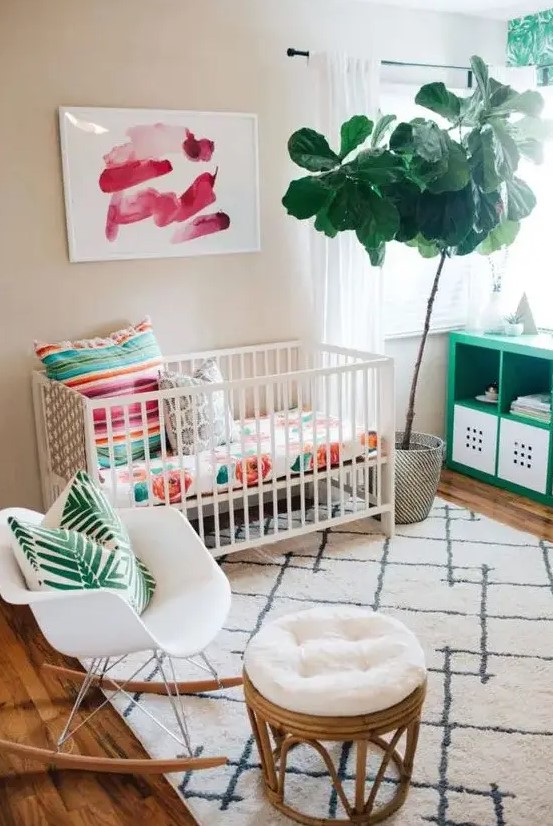 a colorful, tropical-inspired small nursery with flowers, palm prints, potted plants and artwork
