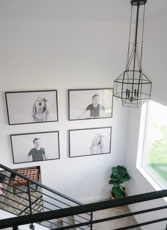 A cool gallery wall with a black and white grid and black frames highlights children's pictures and makes the room fun and cozy