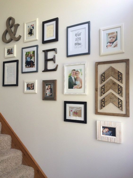 A cool, rustic gallery wall with some family photos, quotes, an ampersand, monograms and wood decor