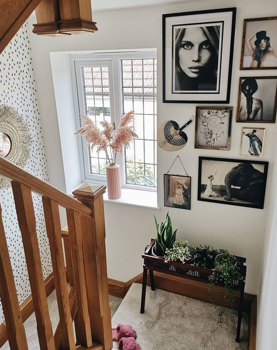 A creative freeform gallery wall with mismatched frames, black and white artwork and a fan to style this space