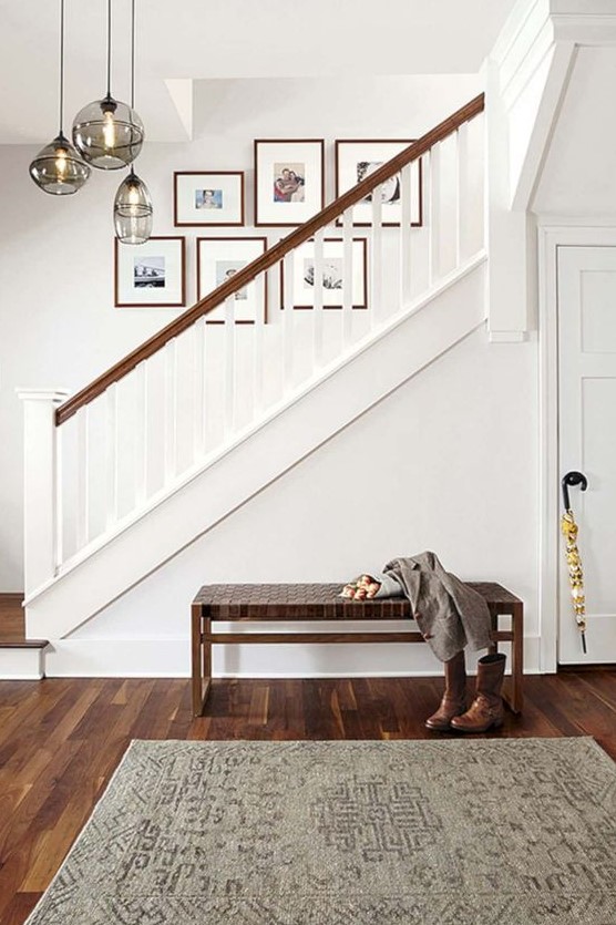 A free-form gallery wall with colorful family photos is a fresh and cool idea to brighten up the space above the stairs