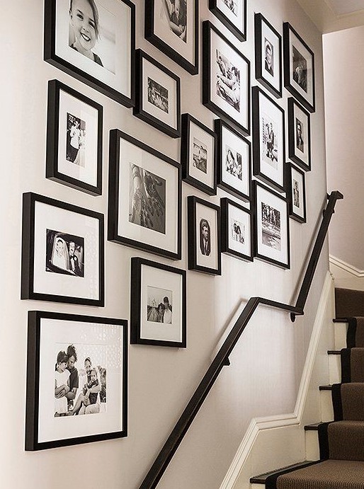 A free-form gallery wall with mismatched black frames and black-and-white photos stylishly refreshes the space