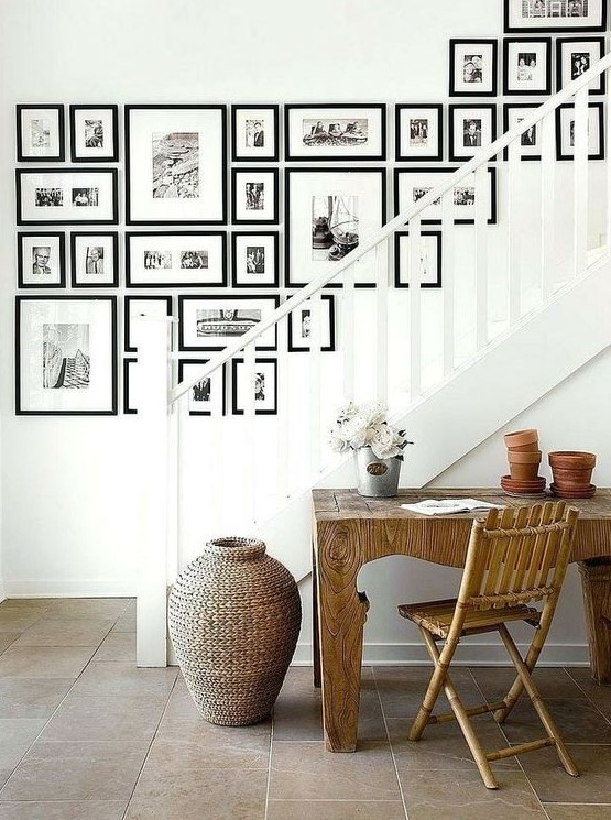 A large freeform gallery wall with black frames and black and white prints is a stylish idea with a versatile yet elegant appeal