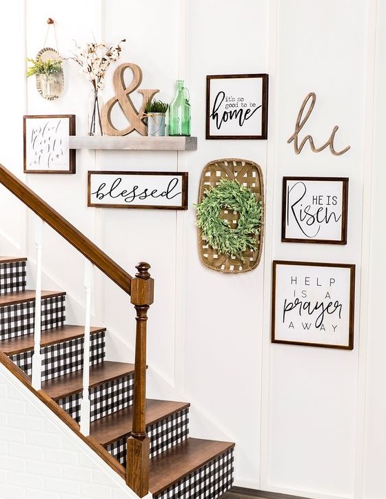 a beautiful rustic gallery wall with signs in stained frames, a green wreath, a shelf with potted grass and an ampersand, and a green bottle