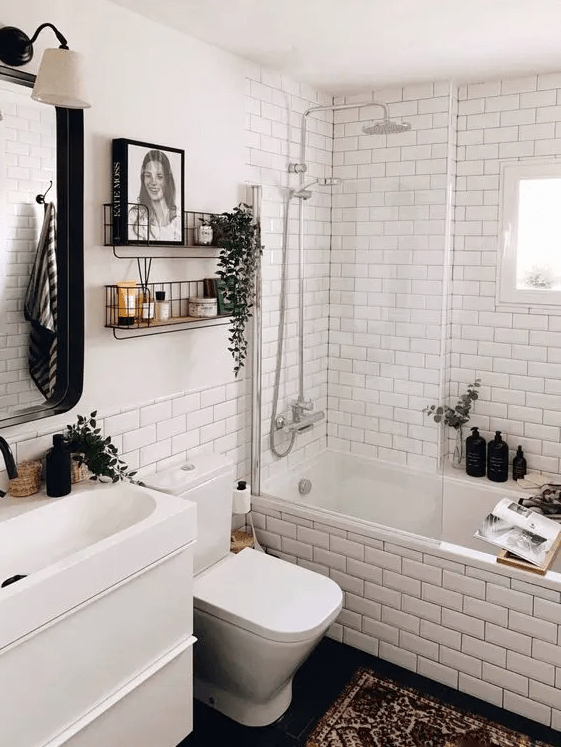 a modern Scandi bathroom with white subway tiles, a white vanity unit with sink, shelves and a mirror with a lamp
