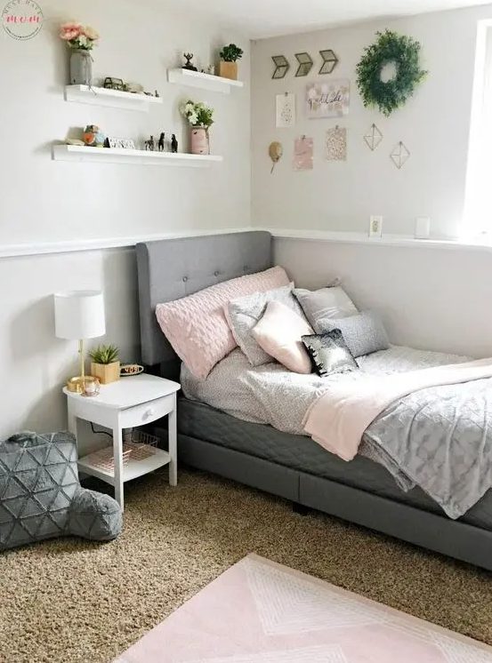 A modern farmhouse teen room with a gray upholstered bed, layered rugs, soft pillows and a gallery wall