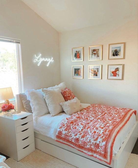 a neutral, modern teenager's room with white furniture, light textiles, a gallery wall and a neon light above the bed
