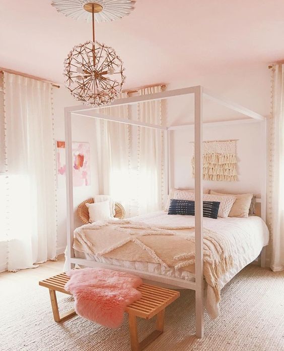 a neutral teen room with a neutral bed and linens, a stained bench with peach faux fur, and a floral chandelier