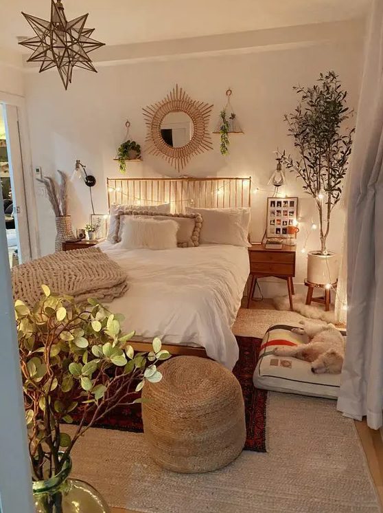 A pretty boho-style teen room with a bed with a metal headboard, bedside tables, potted plants, a dog bed and a jute stool