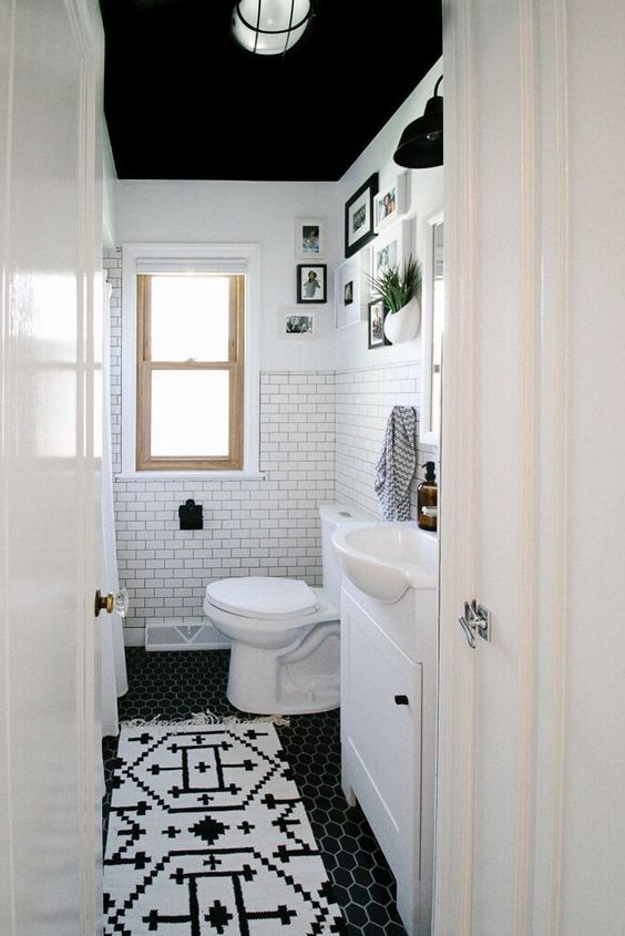 a small black and white bathroom with a black ceiling, white walls, a bathtub, white appliances, a white vanity and a black and white floor