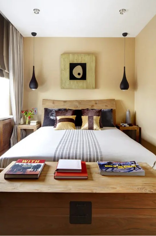 a small, eclectic bedroom with a wooden bed, black pendant lamps, bold printed textiles and cool artwork with a touch of Asia