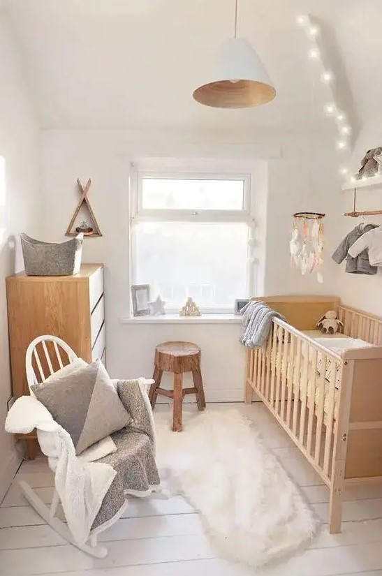 a small organic nursery with stained and white furniture, neutral linens and textiles, a makeshift closet, a pendant lamp and lights