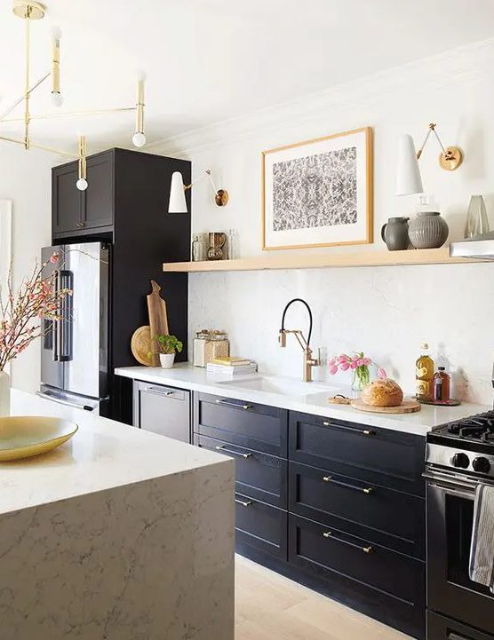 a soot kitchen with open shelving instead of upper cabinets, a kitchen island with a white stone countertop and some gold accents