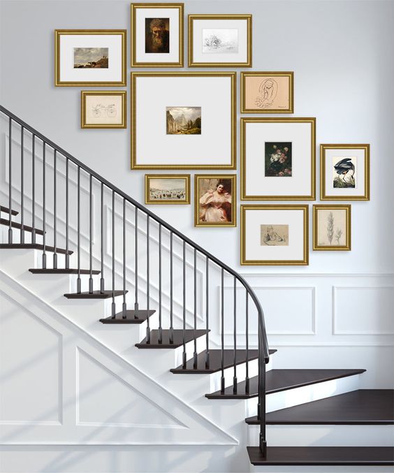 A sophisticated gallery wall with gold-framed artwork arranged in a free-form cluster is a chic decorating idea for an entryway